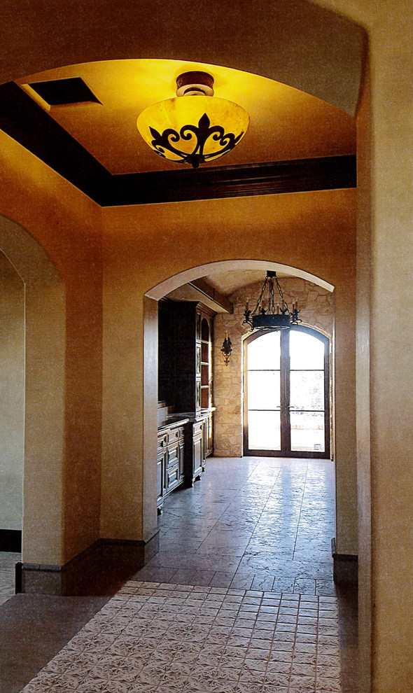 Inspiration for an expansive mediterranean hallway in Las Vegas with yellow walls, travertine floors and beige floor.