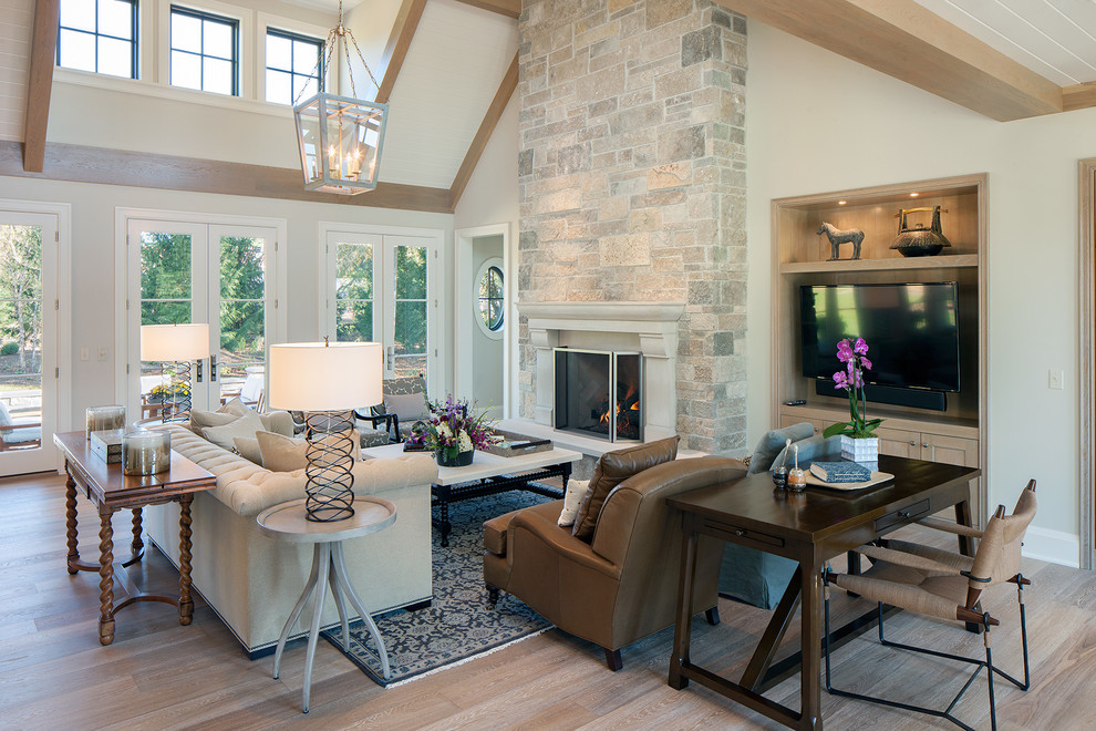 Photo of a large transitional formal open concept living room in Grand Rapids with white walls, a standard fireplace, light hardwood floors, a stone fireplace surround, no tv and brown floor.