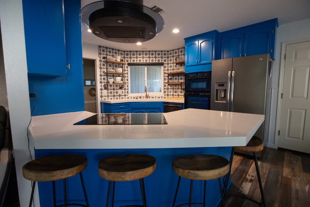 Photo of an eclectic kitchen in Sacramento with blue cabinets, quartz benchtops, multi-coloured splashback, a peninsula and white benchtop.