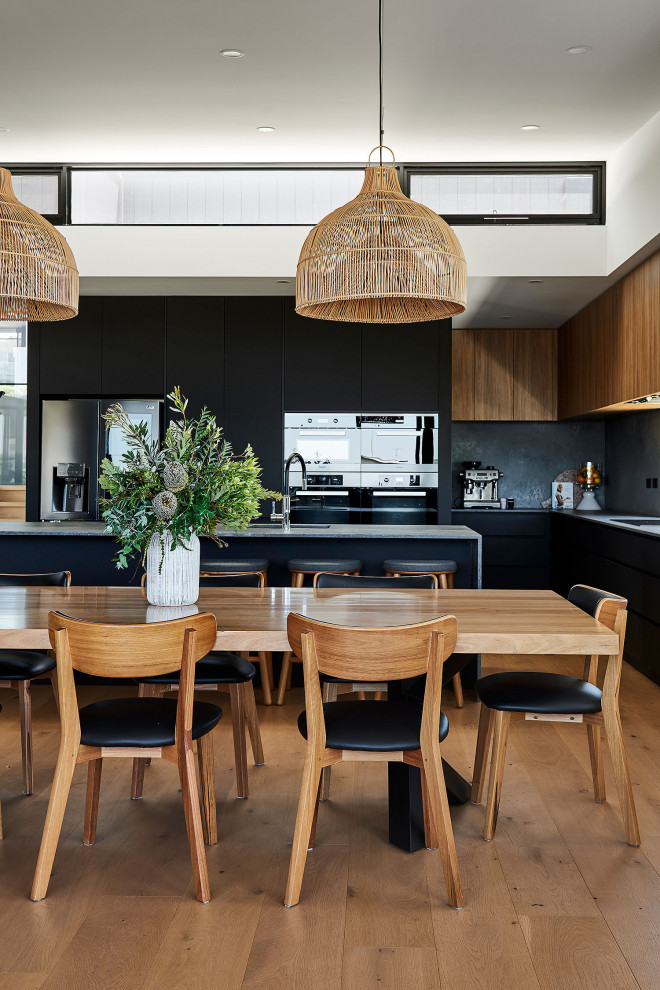 Photo of a large contemporary open plan dining in Geelong with white walls, medium hardwood floors, a ribbon fireplace, a tile fireplace surround, brown floor and vaulted.