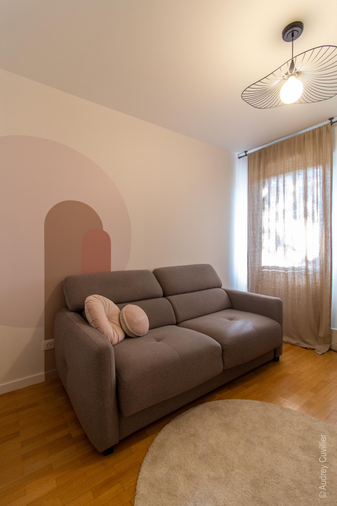 Exempel på ett stort minimalistiskt hemmabibliotek, med rosa väggar, mörkt trägolv och ett fristående skrivbord