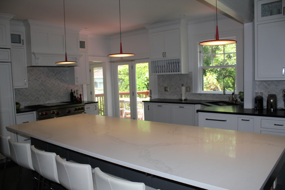 Inspiration for a large transitional dark wood floor and brown floor enclosed kitchen remodel in Boston with a single-bowl sink, shaker cabinets, white cabinets, soapstone countertops, gray backsplash, marble backsplash, stainless steel appliances and an island