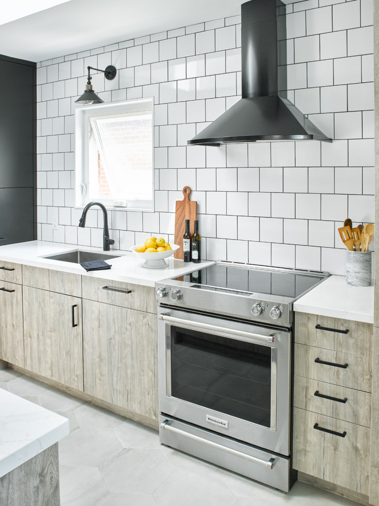 Inspiration for a small modern galley separate kitchen in Toronto with a single-bowl sink, flat-panel cabinets, light wood cabinets, quartz benchtops, white splashback, subway tile splashback, stainless steel appliances, porcelain floors, no island, grey floor and white benchtop.