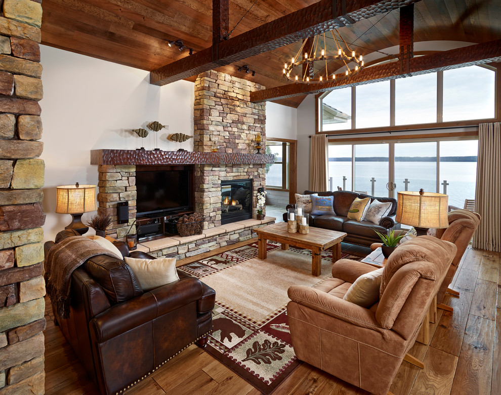 Inspiration for a country living room in Edmonton with a standard fireplace, a stone fireplace surround and a built-in media wall.