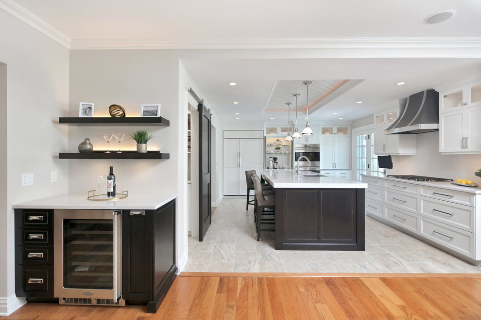 Example of a mid-sized transitional l-shaped porcelain tile and multicolored floor kitchen pantry design in Newark with an undermount sink, recessed-panel cabinets, white cabinets, quartz countertops, white backsplash, paneled appliances, an island and white countertops