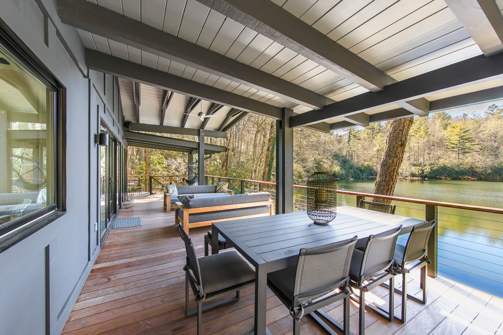 Example of a mountain style cable railing balcony design in Other with a roof extension
