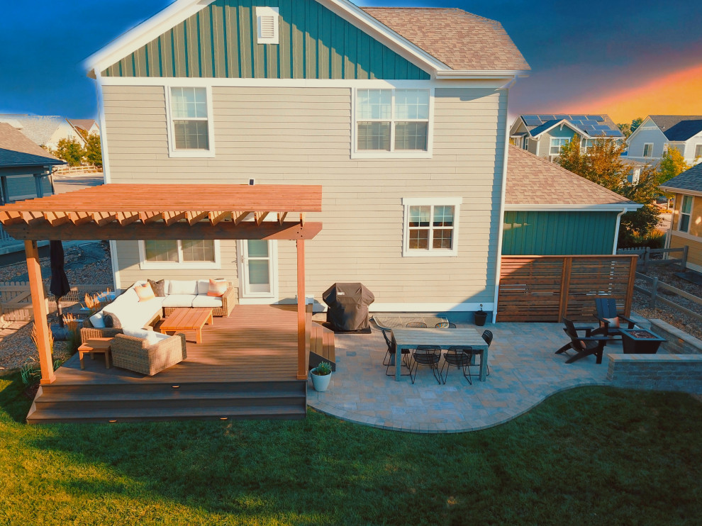 Photo of a mid-sized contemporary backyard and ground level deck in Denver with with privacy feature and a pergola.