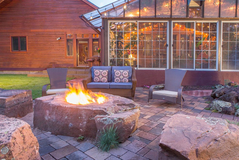 Patio - large rustic backyard brick patio idea in Phoenix with a fire pit and no cover