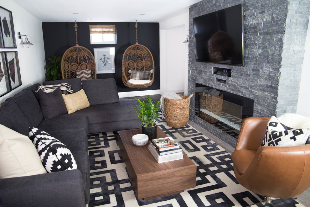 Inspiration for a mid-sized fully buried basement in Toronto with white walls, medium hardwood floors, a standard fireplace, a stone fireplace surround and grey floor.