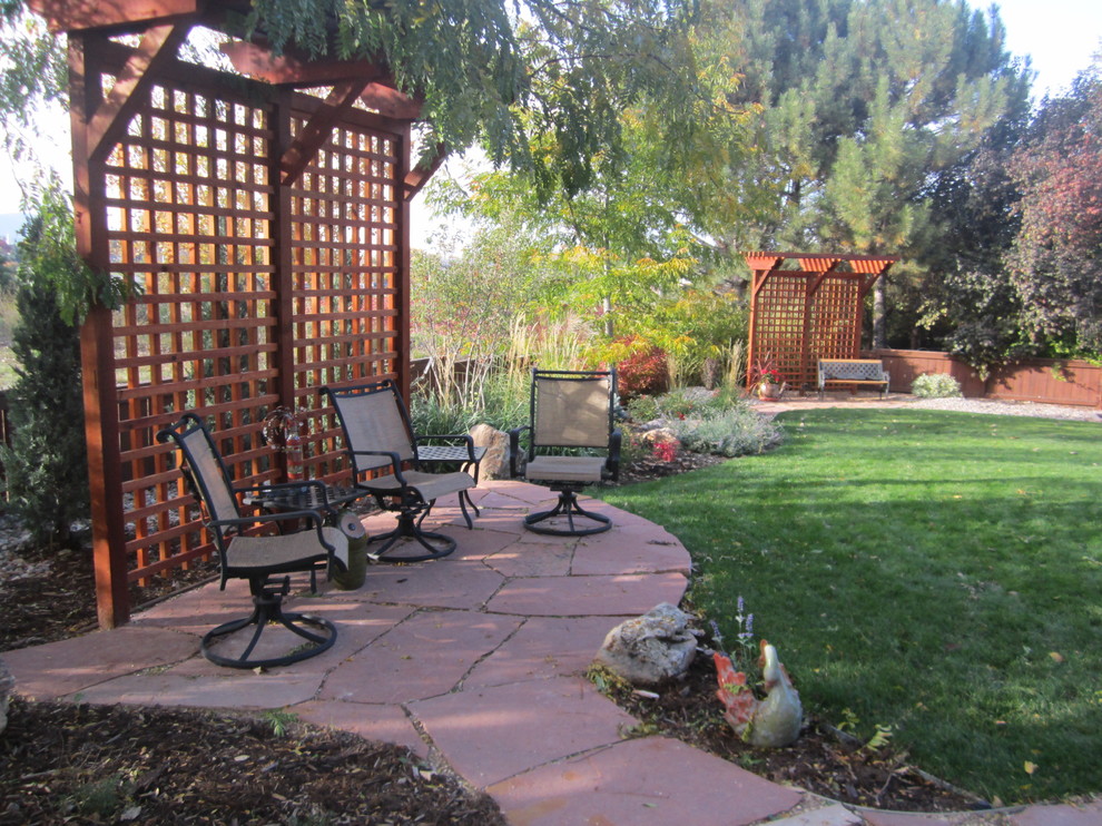Arts and crafts backyard patio in Denver with natural stone pavers.