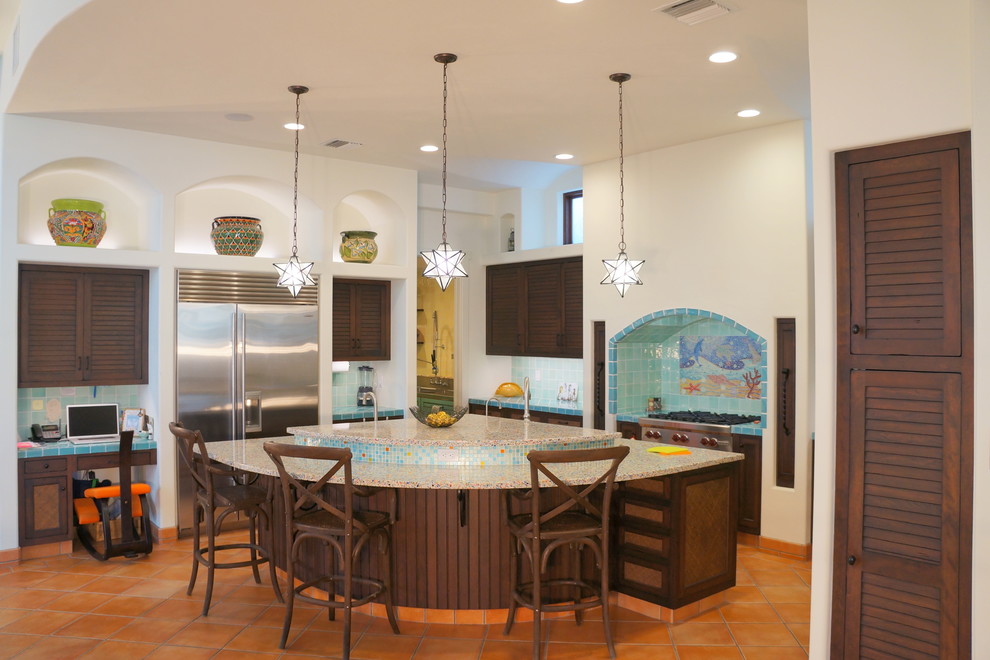 Inspiration for a large mediterranean u-shaped eat-in kitchen in Tampa with an undermount sink, louvered cabinets, brown cabinets, recycled glass benchtops, blue splashback, mosaic tile splashback, stainless steel appliances, terra-cotta floors, with island and orange floor.