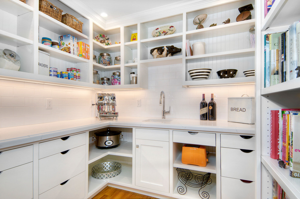 Inspiration for a mid-sized transitional u-shaped kitchen pantry in San Francisco with white cabinets, quartz benchtops, ceramic splashback, an undermount sink, open cabinets, white splashback and light hardwood floors.