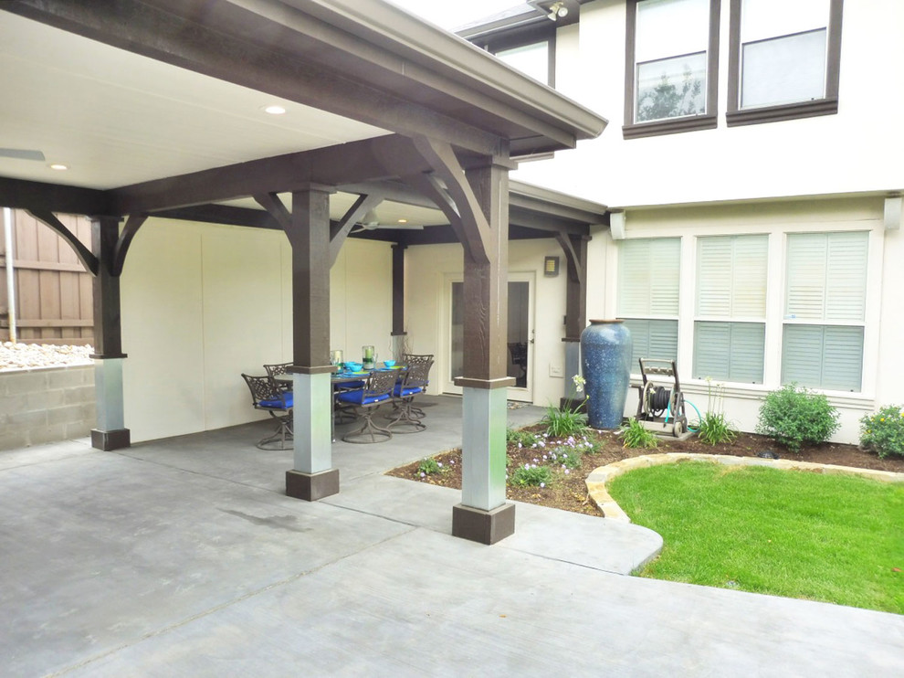 This is an example of a large modern backyard patio in Dallas with concrete slab and a gazebo/cabana.