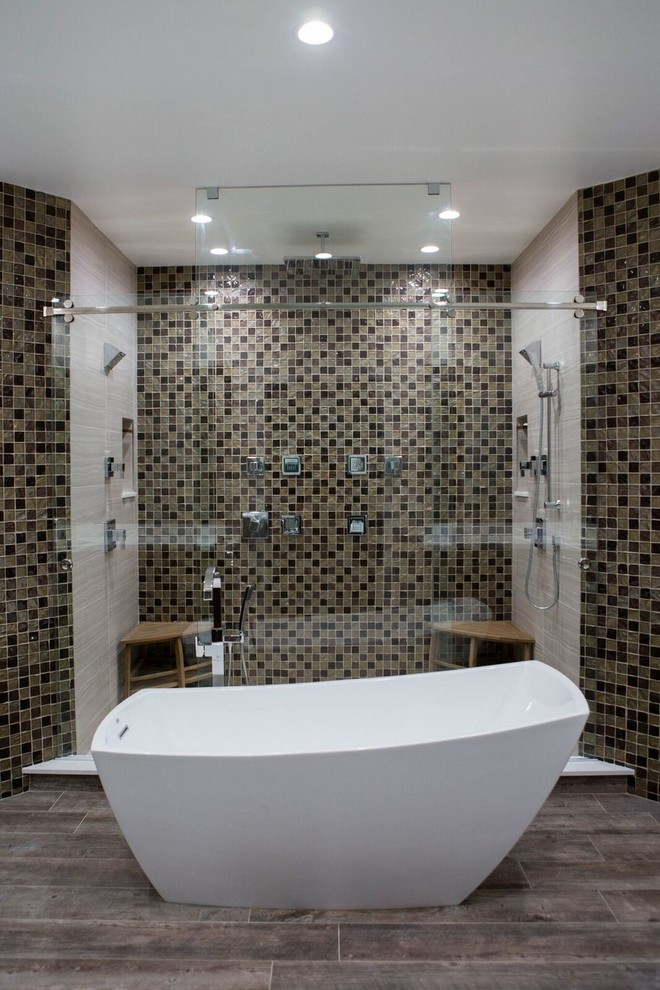 Photo of a large contemporary master bathroom in Miami with a freestanding tub, an alcove shower, a two-piece toilet, beige tile, brown tile, mosaic tile, beige walls and dark hardwood floors.