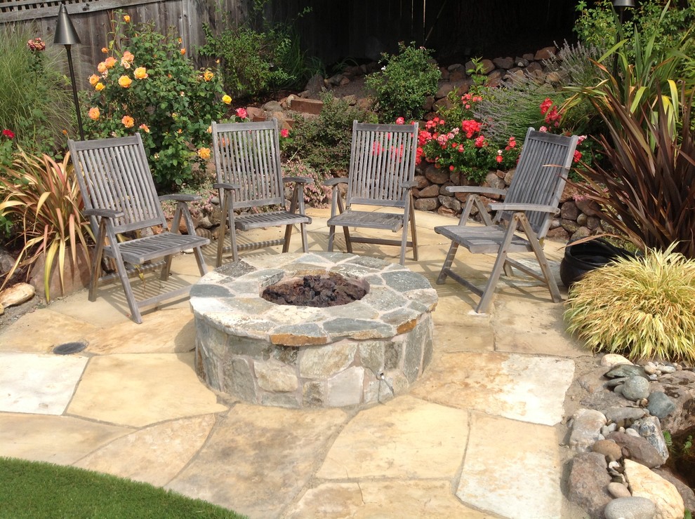 Photo of a mid-sized traditional backyard patio in San Francisco with a fire feature, natural stone pavers and no cover.