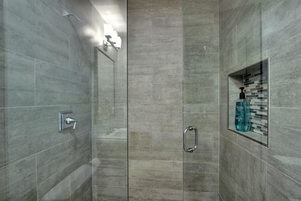This is an example of a mid-sized transitional 3/4 bathroom in San Francisco with an alcove shower, gray tile, a hinged shower door, a two-piece toilet, a pedestal sink, grey floor, tile benchtops, ceramic tile, grey walls and ceramic floors.