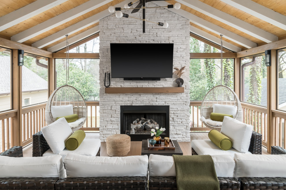 Réalisation d'un grand porche d'entrée de maison arrière minimaliste avec une moustiquaire, une terrasse en bois, une extension de toiture et un garde-corps en bois.