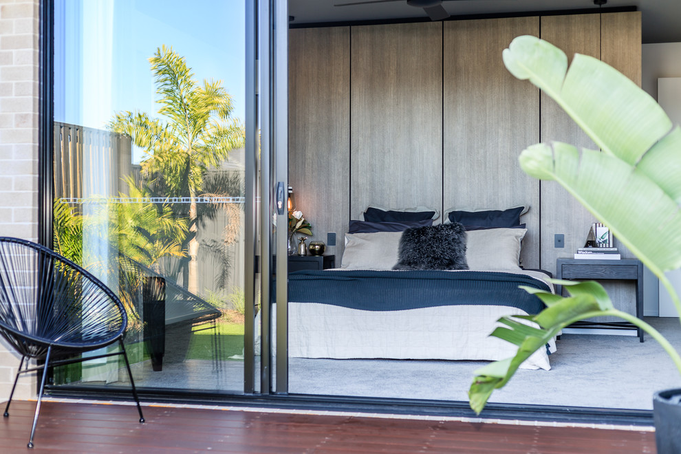 This is an example of an expansive contemporary master bedroom in Brisbane with beige walls, carpet and grey floor.