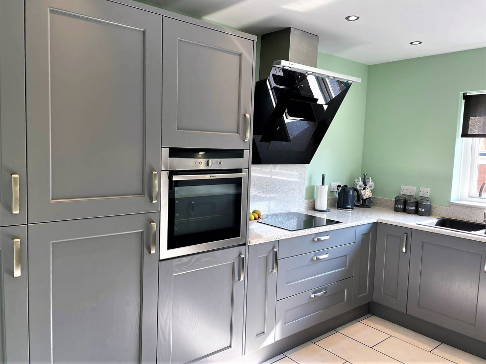 Photo of a mid-sized traditional u-shaped separate kitchen in Other with a drop-in sink, shaker cabinets, grey cabinets, white splashback, stainless steel appliances, no island, white floor, white benchtop and porcelain floors.