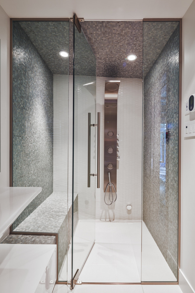This is an example of a contemporary bathroom in Montreal with flat-panel cabinets, white cabinets, a wall-mount toilet, gray tile, mosaic tile, white walls, ceramic floors, a wall-mount sink and with a sauna.
