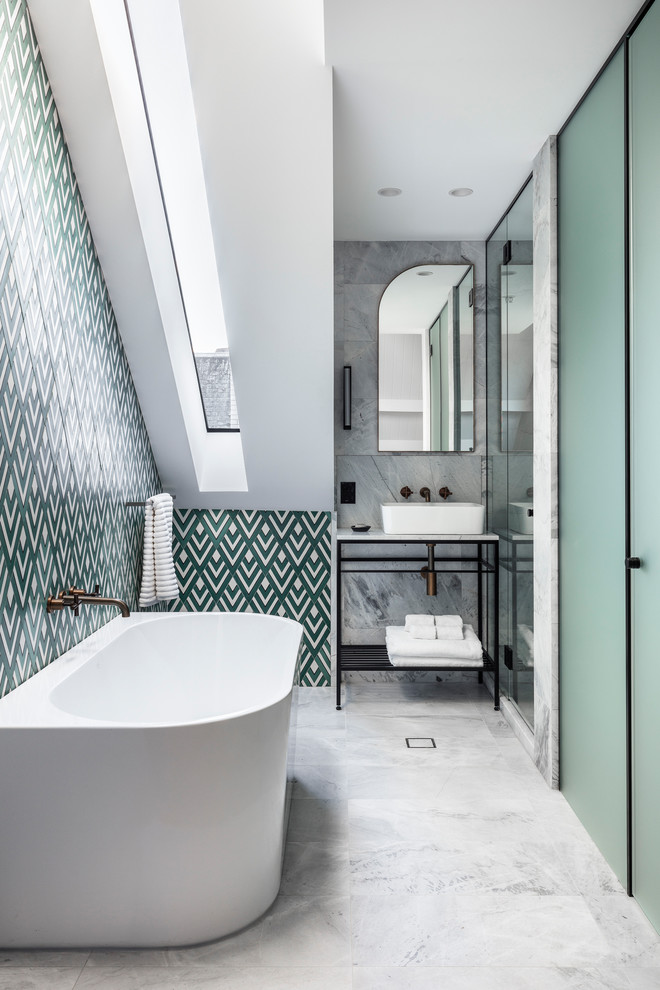 This is an example of a transitional bathroom in Sydney with a freestanding tub, multi-coloured tile, white walls, a vessel sink and grey floor.