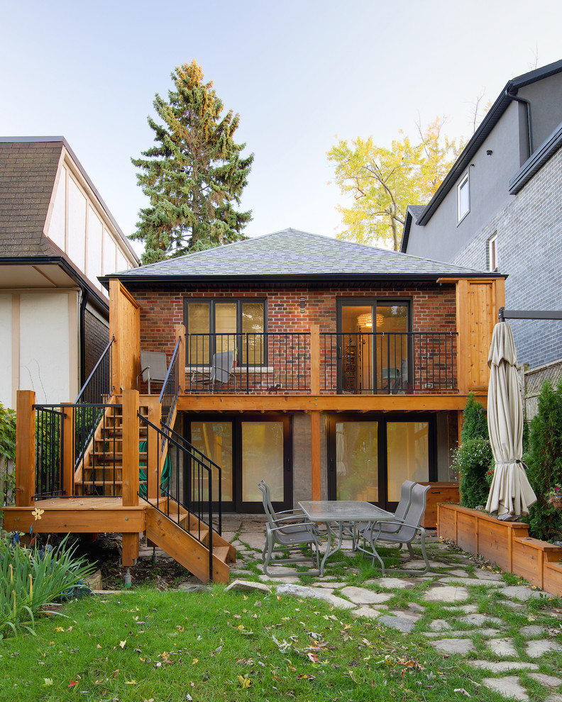 This is an example of a small transitional one-storey brick red exterior in Toronto with a gable roof.