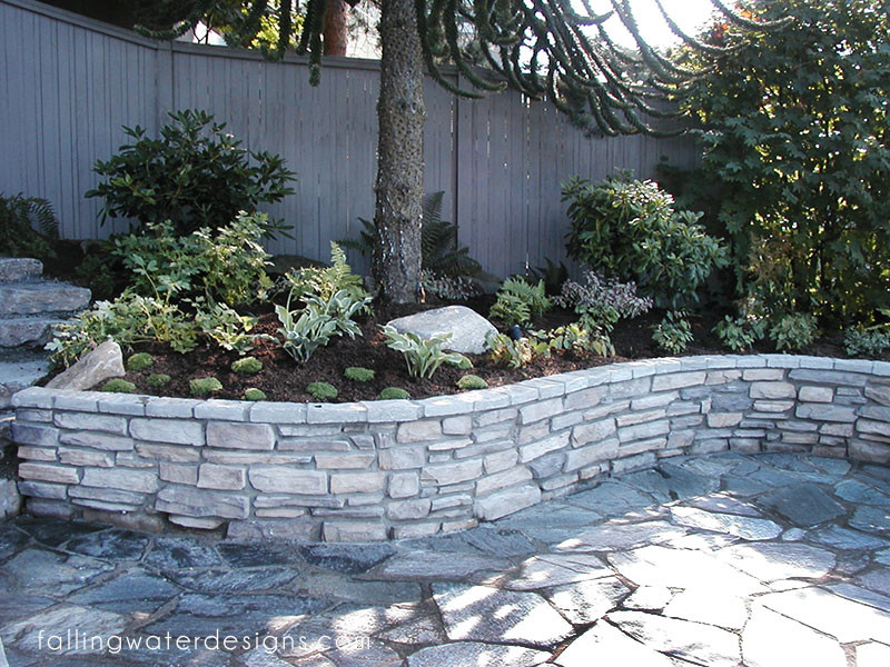 Inspiration for a huge contemporary partial sun backyard stone retaining wall landscape in Seattle for summer.