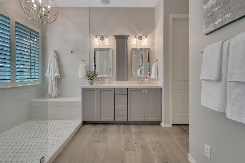 Inspiration for a mid-sized transitional master white tile and porcelain tile wood-look tile floor, multicolored floor and double-sink doorless shower remodel in Phoenix with shaker cabinets, gray cabinets, gray walls, an undermount sink, granite countertops, white countertops and a niche