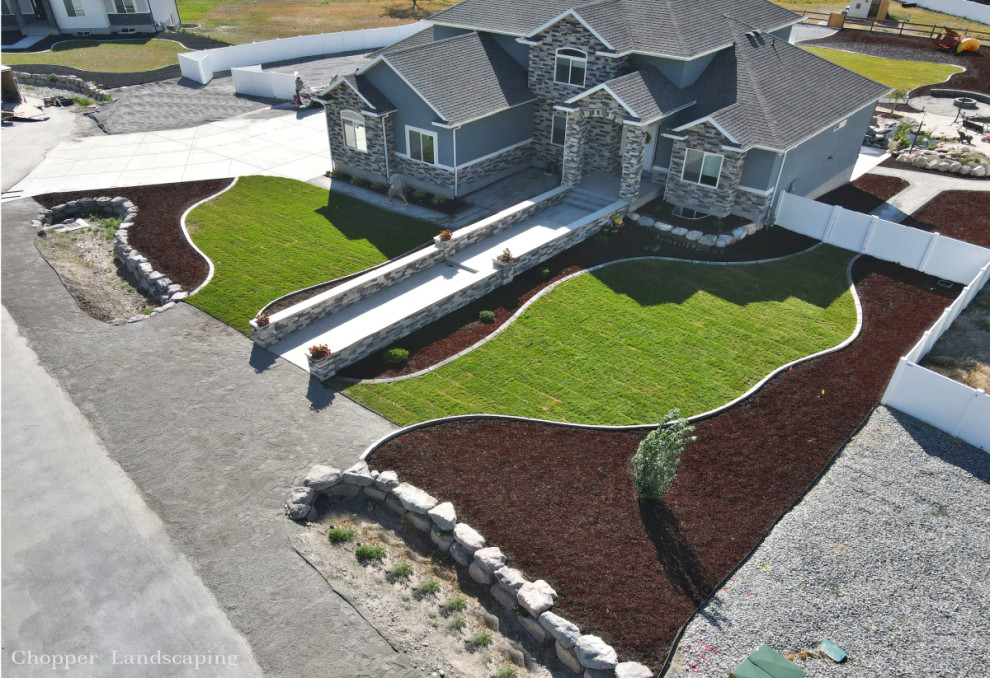 Large country front yard full sun formal garden in Salt Lake City with with path and concrete pavers for spring.