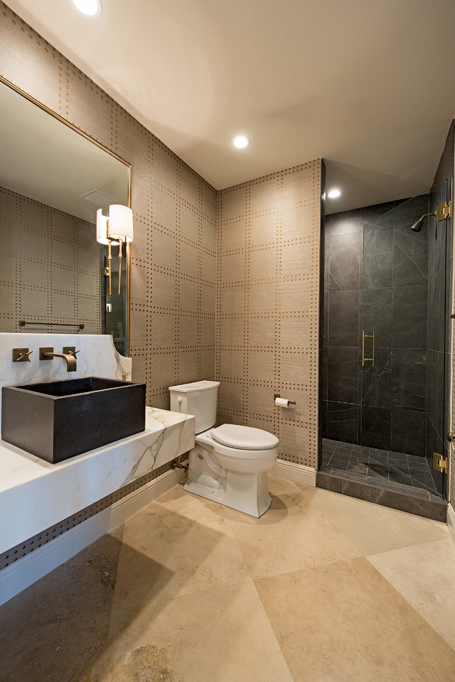 Photo of a large contemporary 3/4 bathroom in Miami with open cabinets, an alcove shower, a two-piece toilet, gray tile, slate, brown walls, porcelain floors, a vessel sink, marble benchtops, beige floor and a hinged shower door.