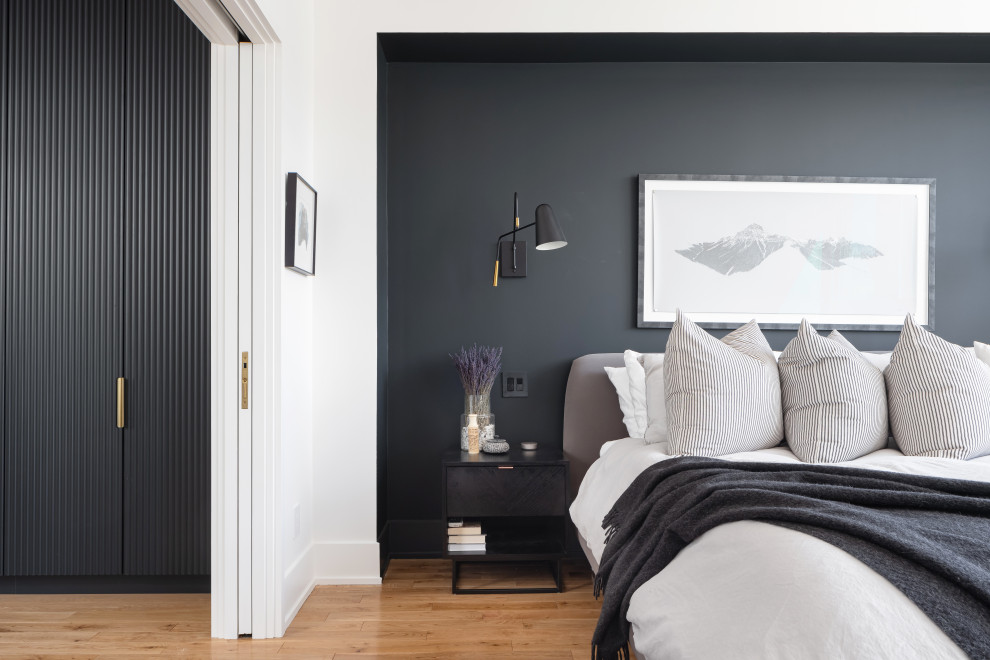 Inspiration for a modern master bedroom in Toronto with black walls, medium hardwood flooring, no fireplace and brown floors.
