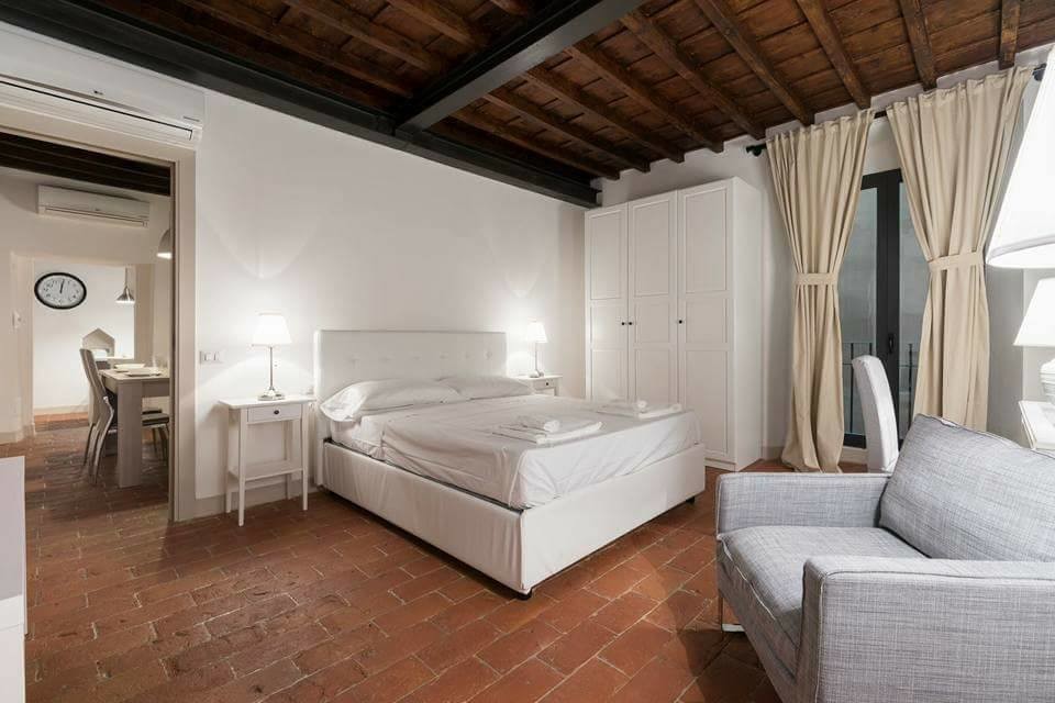 Design ideas for a modern master bedroom in Florence with white walls, brick floors and red floor.