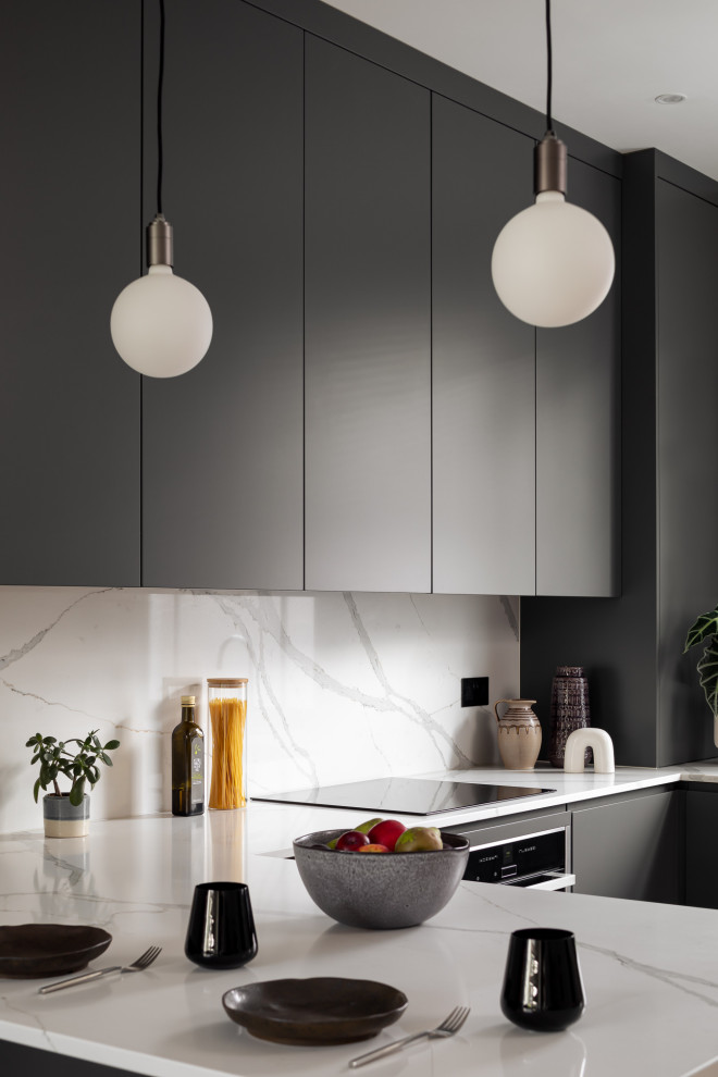 Réalisation d'une petite cuisine minimaliste en U avec des portes de placard grises, un plan de travail en quartz, une crédence blanche et un plan de travail blanc.