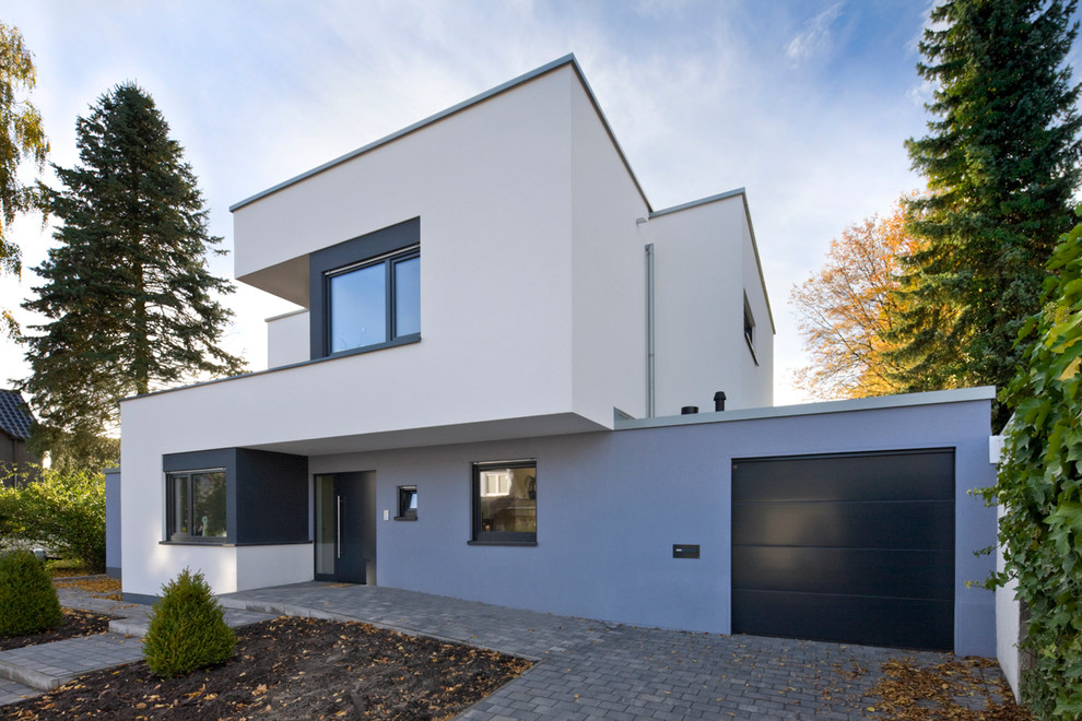 Large contemporary two-storey stucco exterior in Dortmund with a flat roof.