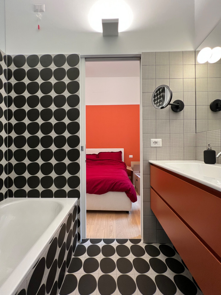 На фото: главная ванная комната среднего размера в стиле модернизм с оранжевыми фасадами, раздельным унитазом, черно-белой плиткой, керамогранитной плиткой, белыми стенами, полом из керамогранита, монолитной раковиной, черным полом, белой столешницей, тумбой под одну раковину и подвесной тумбой с