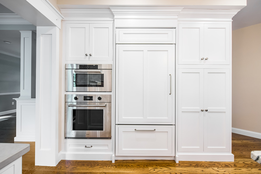 Photo of a mid-sized traditional u-shaped separate kitchen in Boston with an undermount sink, shaker cabinets, stainless steel appliances, dark hardwood floors, with island, white cabinets, granite benchtops, beige splashback and porcelain splashback.