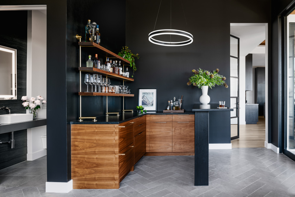 Réalisation d'un bar de salon design en U et bois brun avec aucun évier ou lavabo, un placard à porte plane, une crédence noire, un sol gris et plan de travail noir.