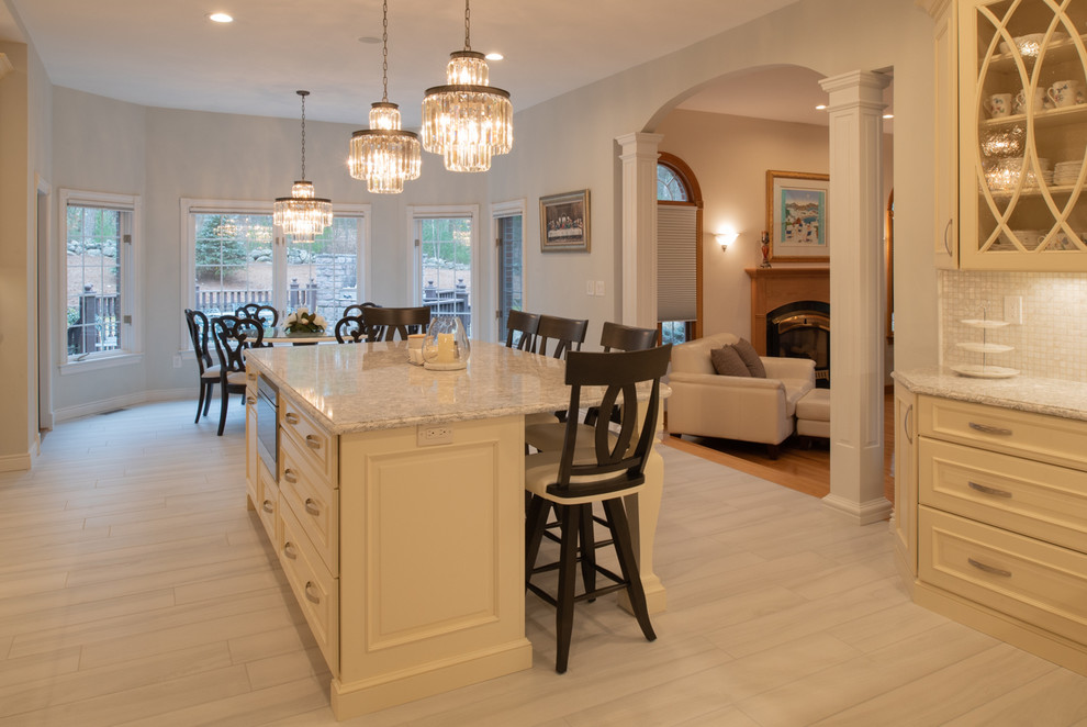 Photo of an expansive traditional eat-in kitchen in Boston with raised-panel cabinets, white cabinets, quartz benchtops, white splashback, mosaic tile splashback, stainless steel appliances, porcelain floors, multiple islands, grey floor and beige benchtop.