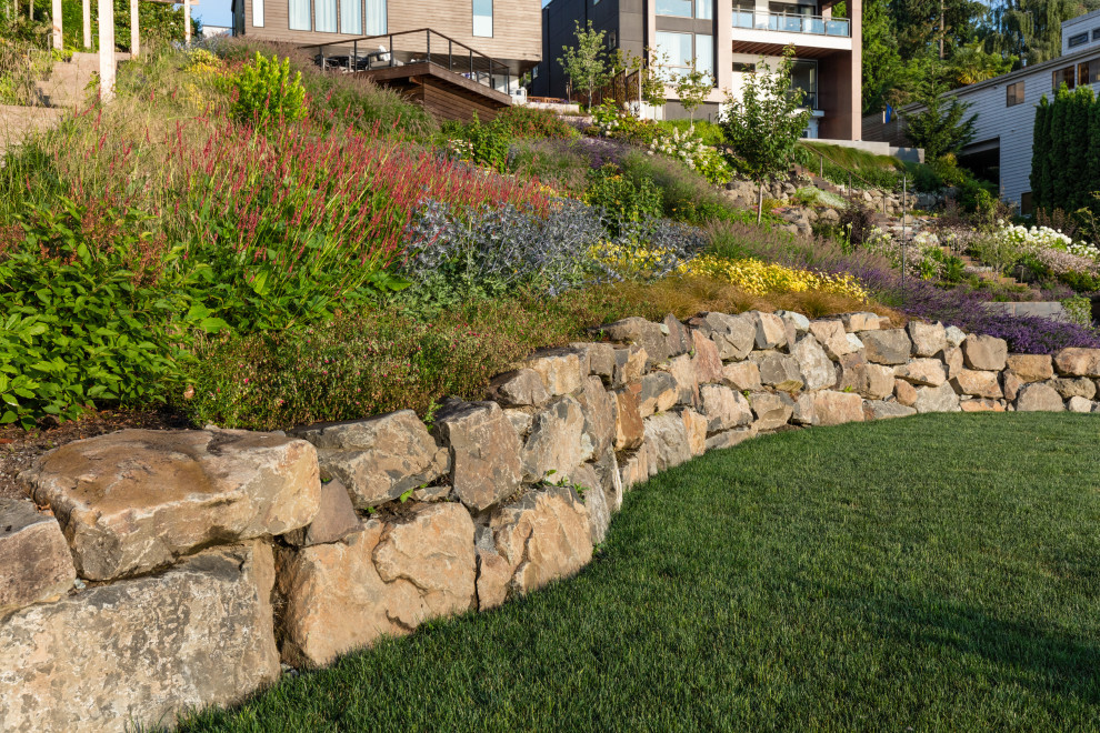 Ispirazione per un grande giardino minimal esposto in pieno sole in estate con un pendio, una collina o una riva, ghiaia e recinzione in metallo