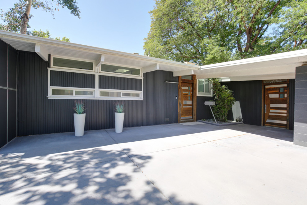This is an example of a small midcentury one-storey multi-coloured house exterior in Denver with mixed siding.