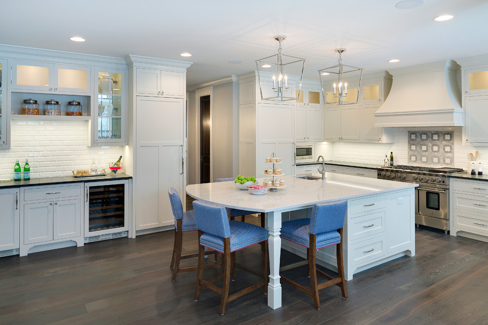 Inspiration for a large traditional u-shaped open plan kitchen in Minneapolis with an undermount sink, shaker cabinets, white cabinets, white splashback, dark hardwood floors, with island, marble benchtops, subway tile splashback and panelled appliances.