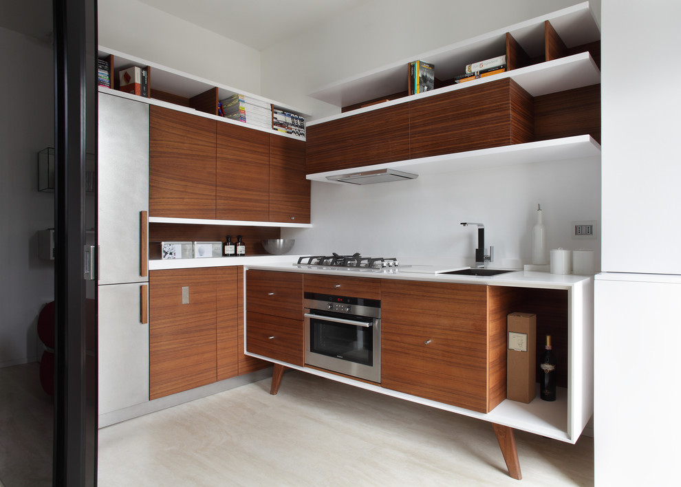 Inspiration for a mid-sized modern l-shaped kitchen in Milan with an undermount sink, flat-panel cabinets, medium wood cabinets, solid surface benchtops, stainless steel appliances and marble floors.