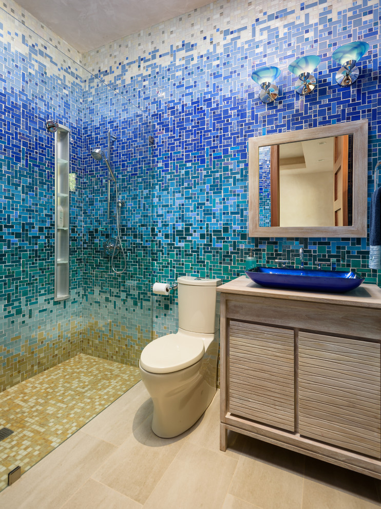 Design ideas for a tropical 3/4 bathroom in Hawaii with flat-panel cabinets, light wood cabinets, a curbless shower, beige tile, blue tile, green tile, white tile, mosaic tile, a vessel sink, wood benchtops, beige floor and beige benchtops.