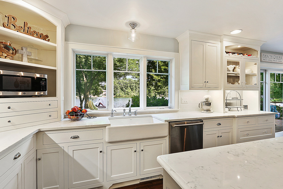 Inspiration for a transitional kitchen remodel with white cabinets, white backsplash and an island