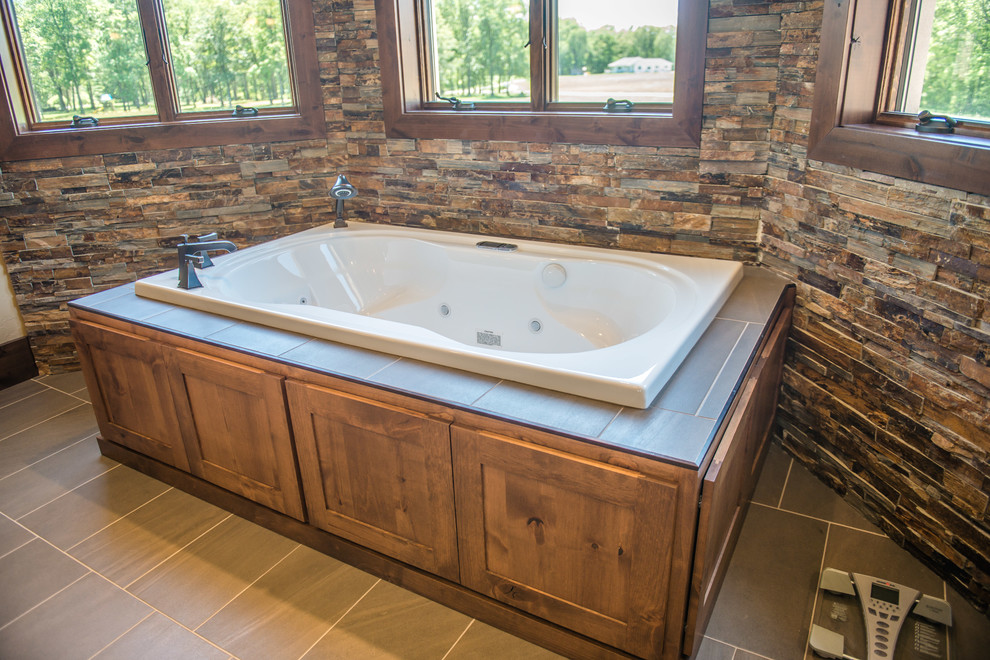 Inspiration for an expansive country master bathroom in Other with flat-panel cabinets, medium wood cabinets, a freestanding tub, an open shower, a one-piece toilet, slate, multi-coloured walls, porcelain floors, an undermount sink, marble benchtops, brown floor and an open shower.