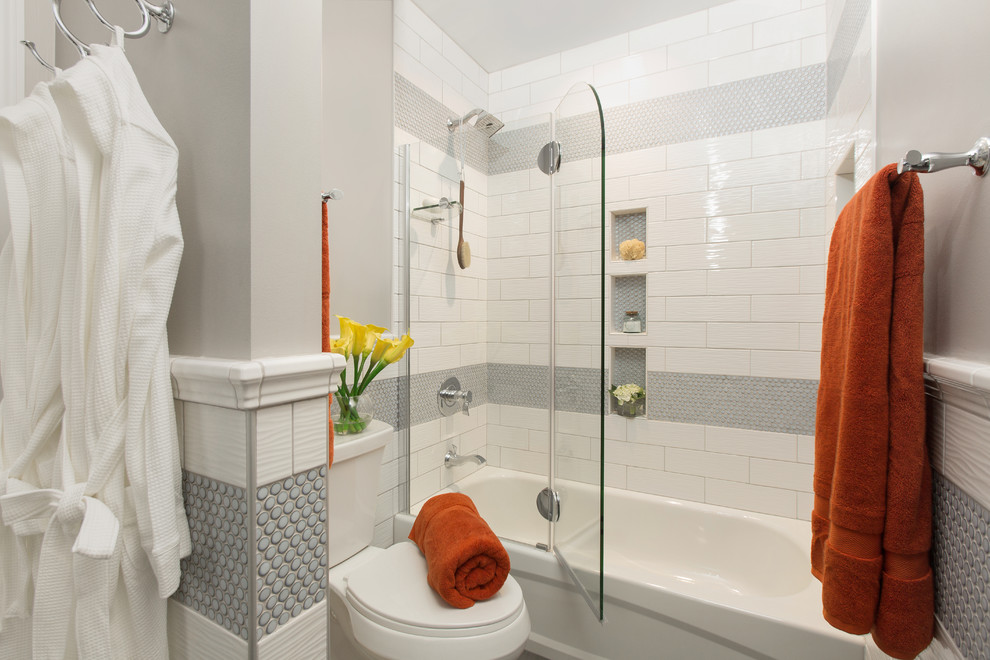 Photo of a mid-sized transitional 3/4 bathroom in St Louis with white cabinets, a corner tub, a shower/bathtub combo, a two-piece toilet, white tile, subway tile, an undermount sink, granite benchtops, a hinged shower door, grey walls, porcelain floors, grey floor and white benchtops.