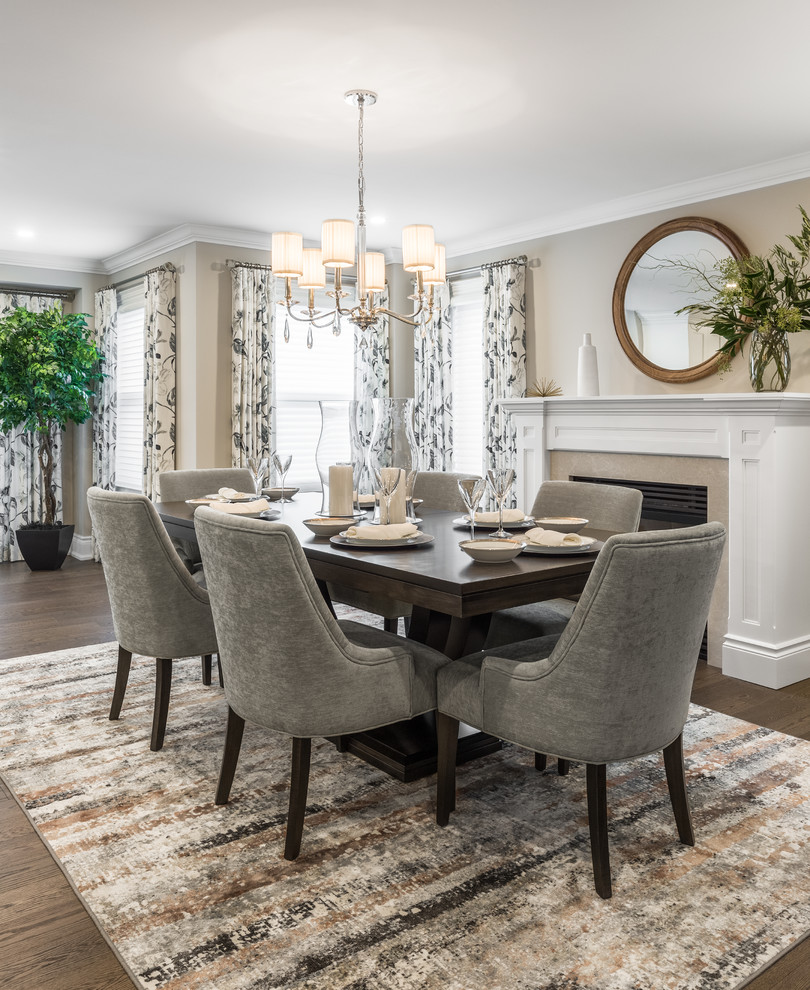 Design ideas for a mid-sized transitional separate dining room in Toronto with beige walls, dark hardwood floors, a standard fireplace, a stone fireplace surround and brown floor.