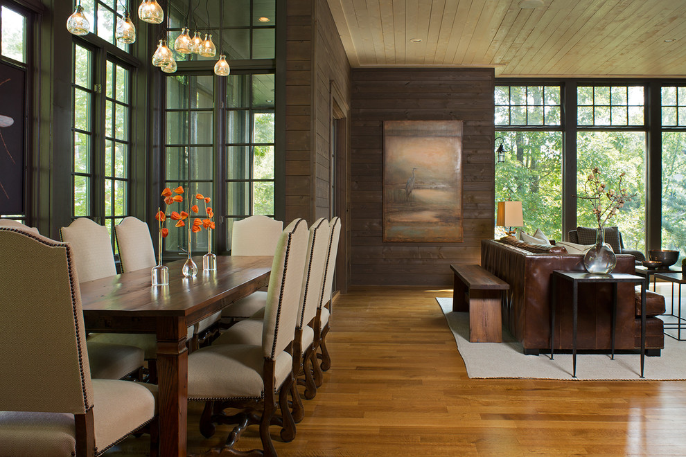 Large arts and crafts open plan dining in Charlotte with brown walls, light hardwood floors and brown floor.