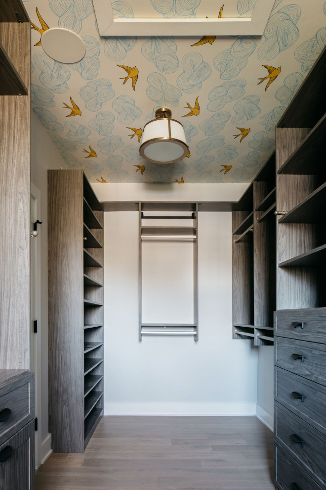 This is an example of a large traditional gender neutral walk-in wardrobe in Chicago with shaker cabinets, dark wood cabinets, dark hardwood flooring, brown floors and a wallpapered ceiling.