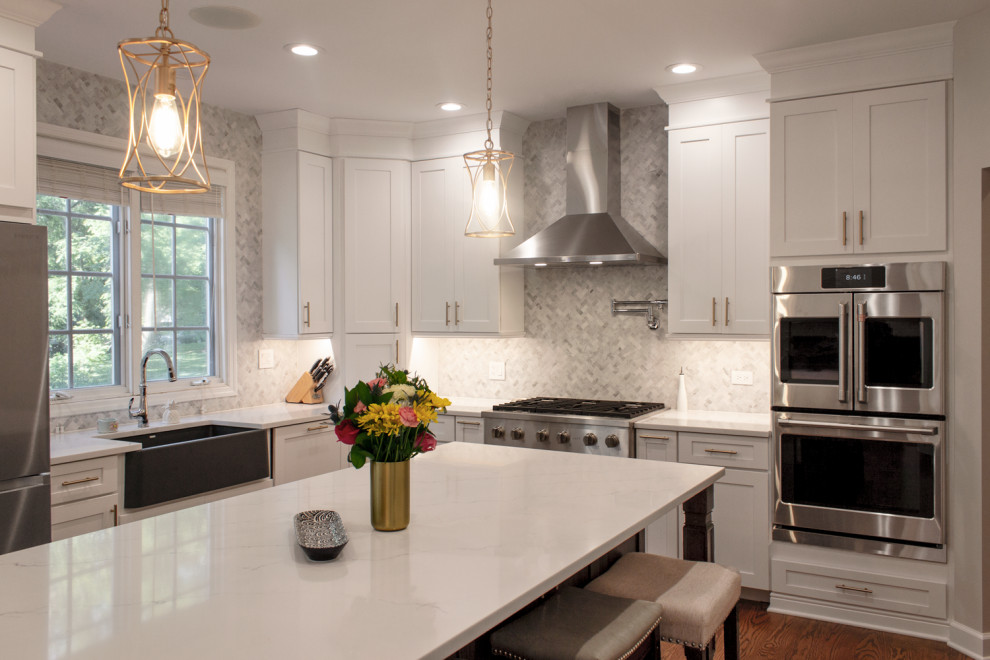 Immagine di una grande cucina classica con ante in stile shaker, ante bianche, paraspruzzi grigio, elettrodomestici in acciaio inossidabile e top bianco